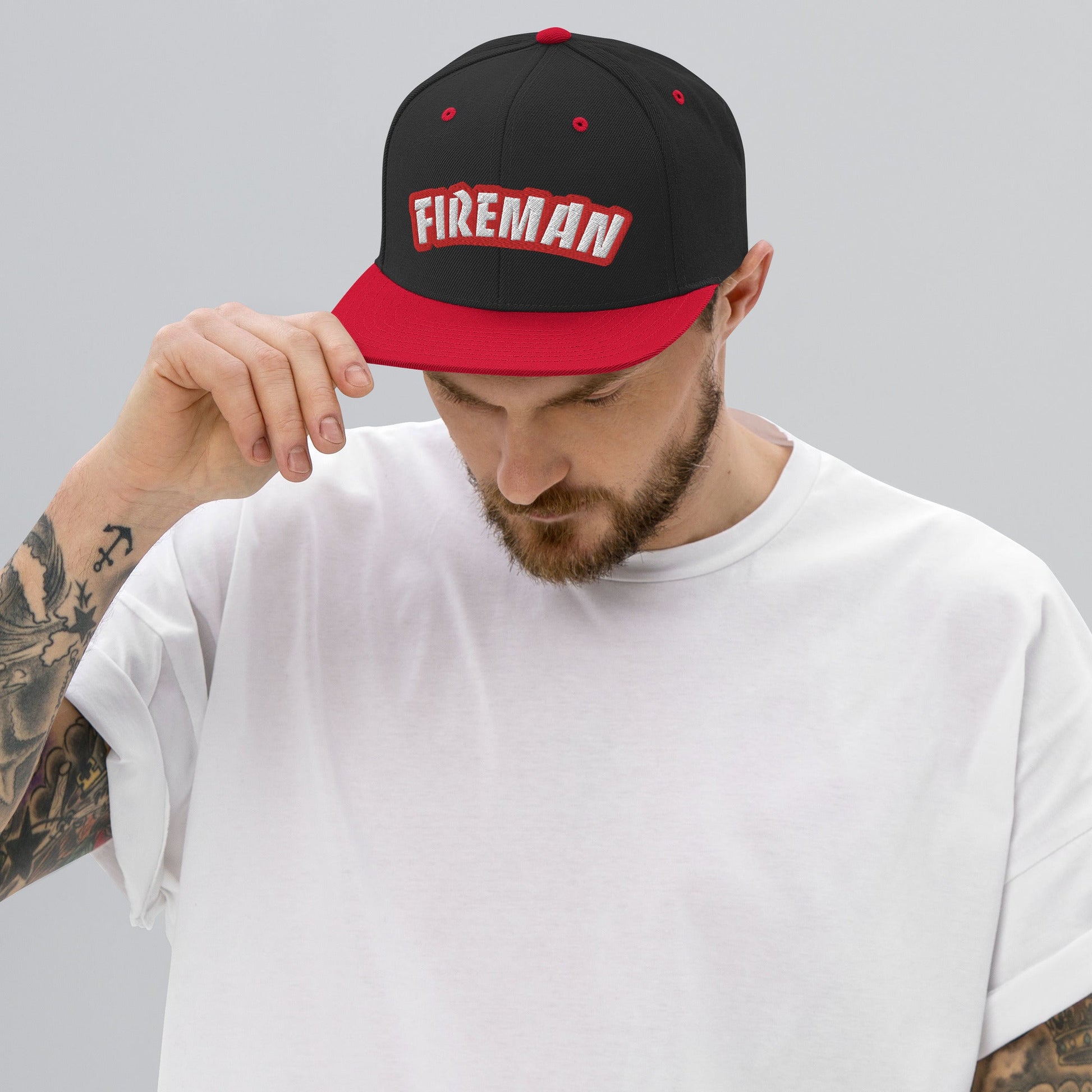 Man wearing Black and red snapback with Fireman text on grey background