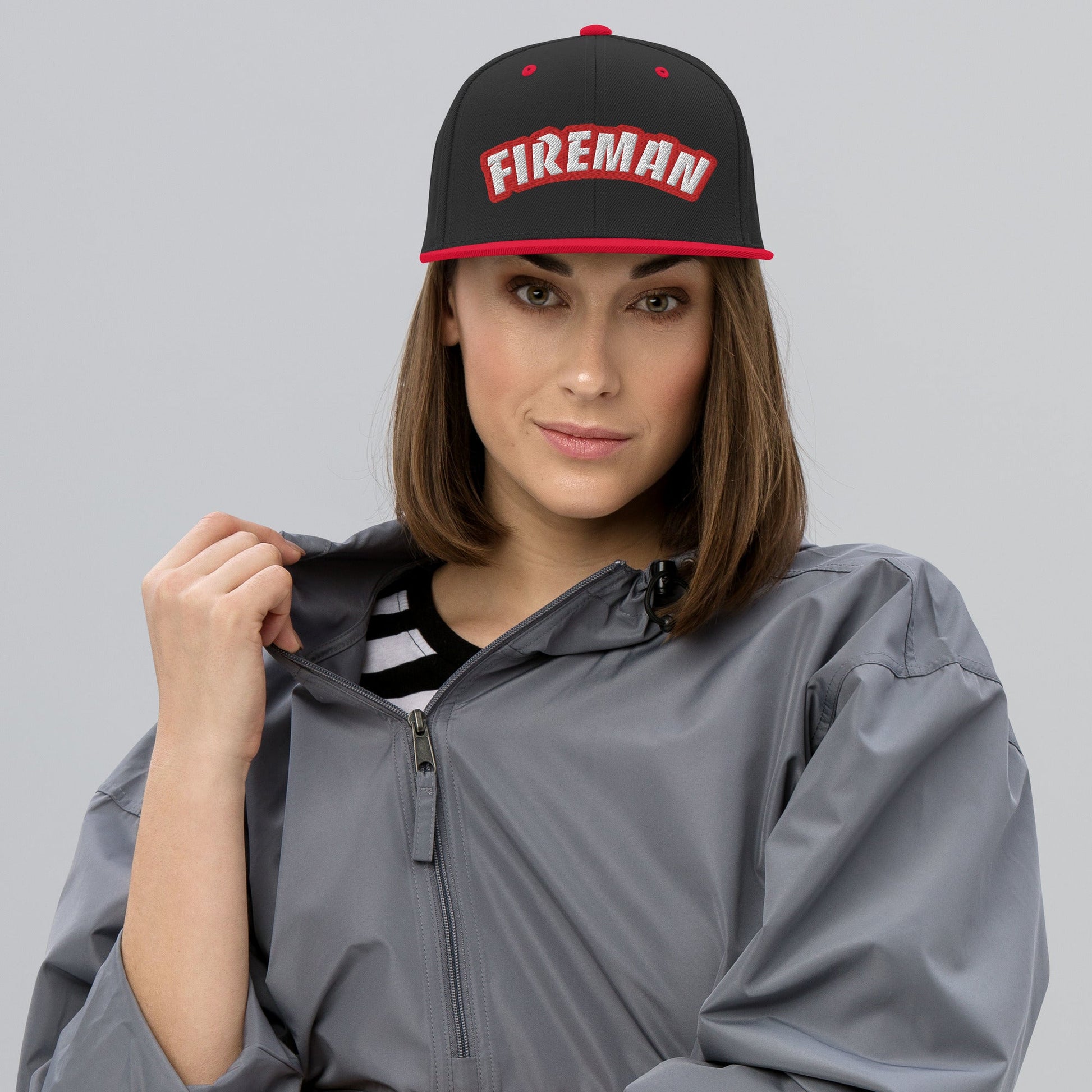 Woman wearing black and red snapback with Fireman text on white background